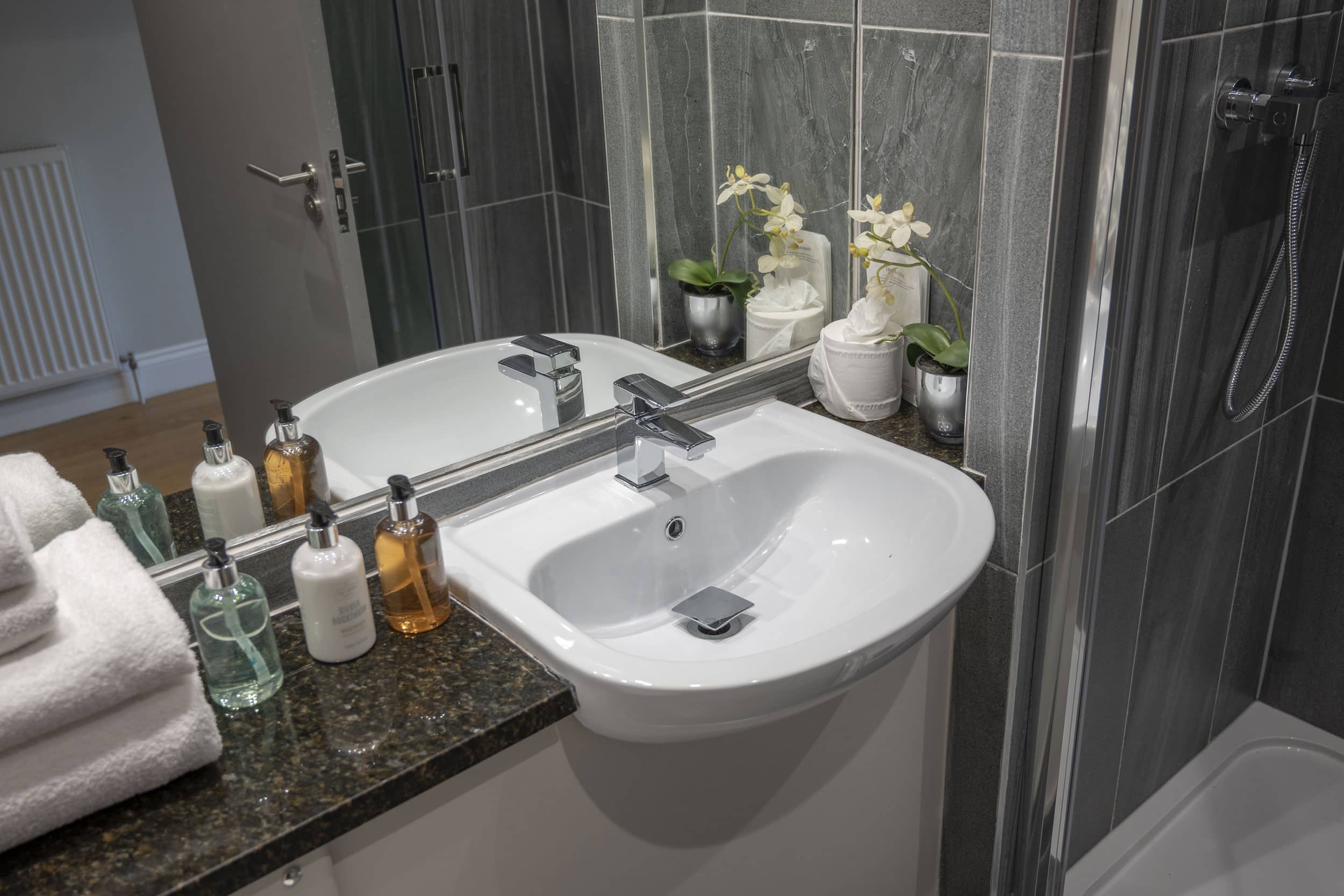 Shower room with handbasin shower and towels
