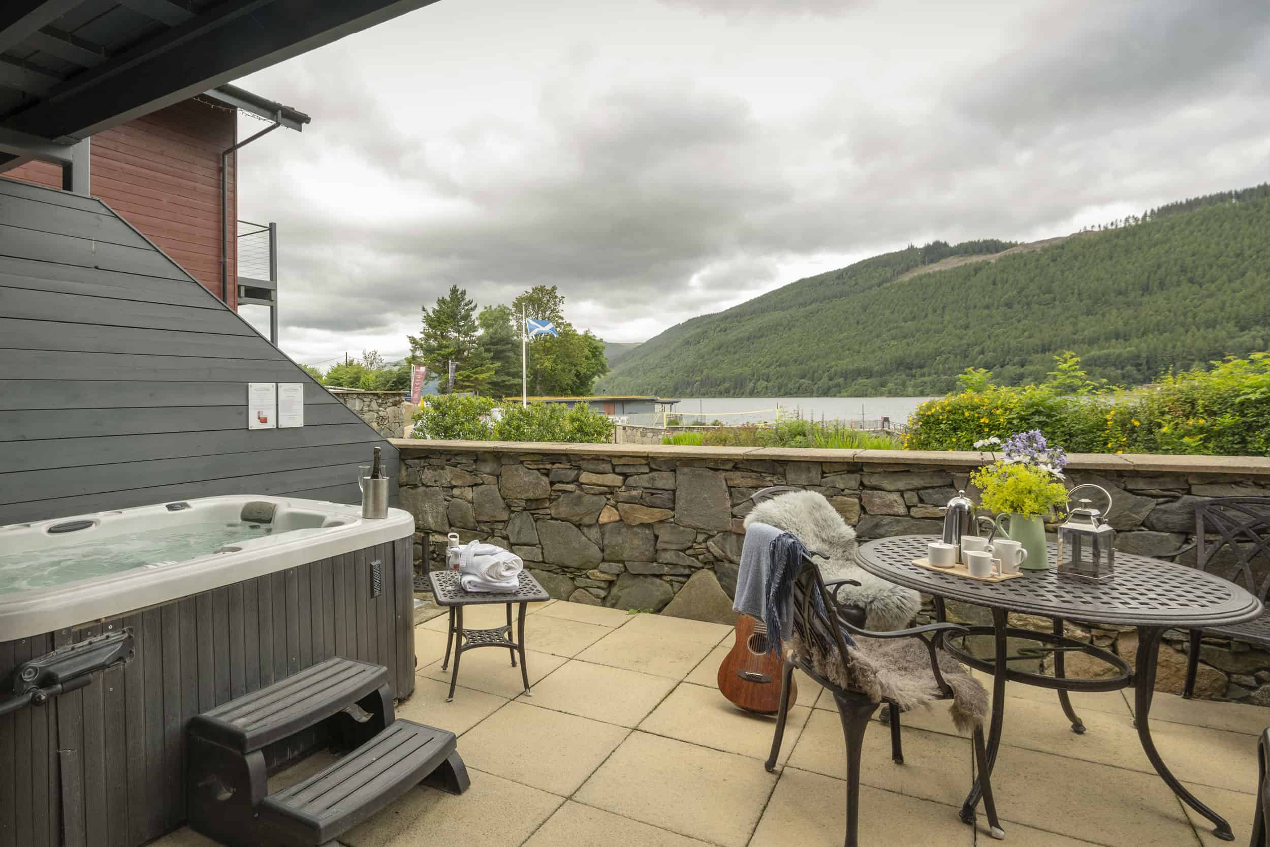 Terrace seating with views across loch tay and forest.